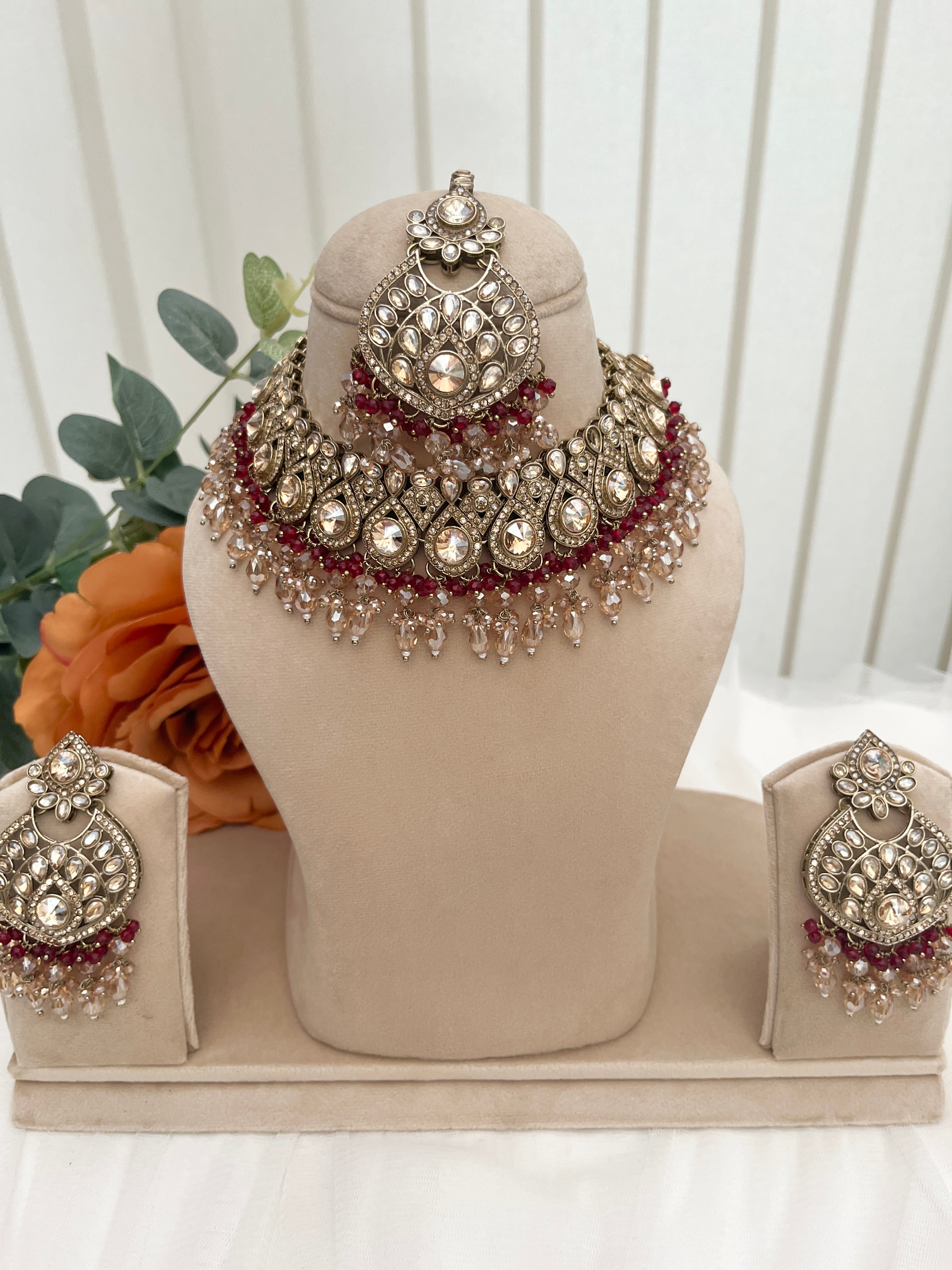Gold and burgundy Polki diamonds necklace set.