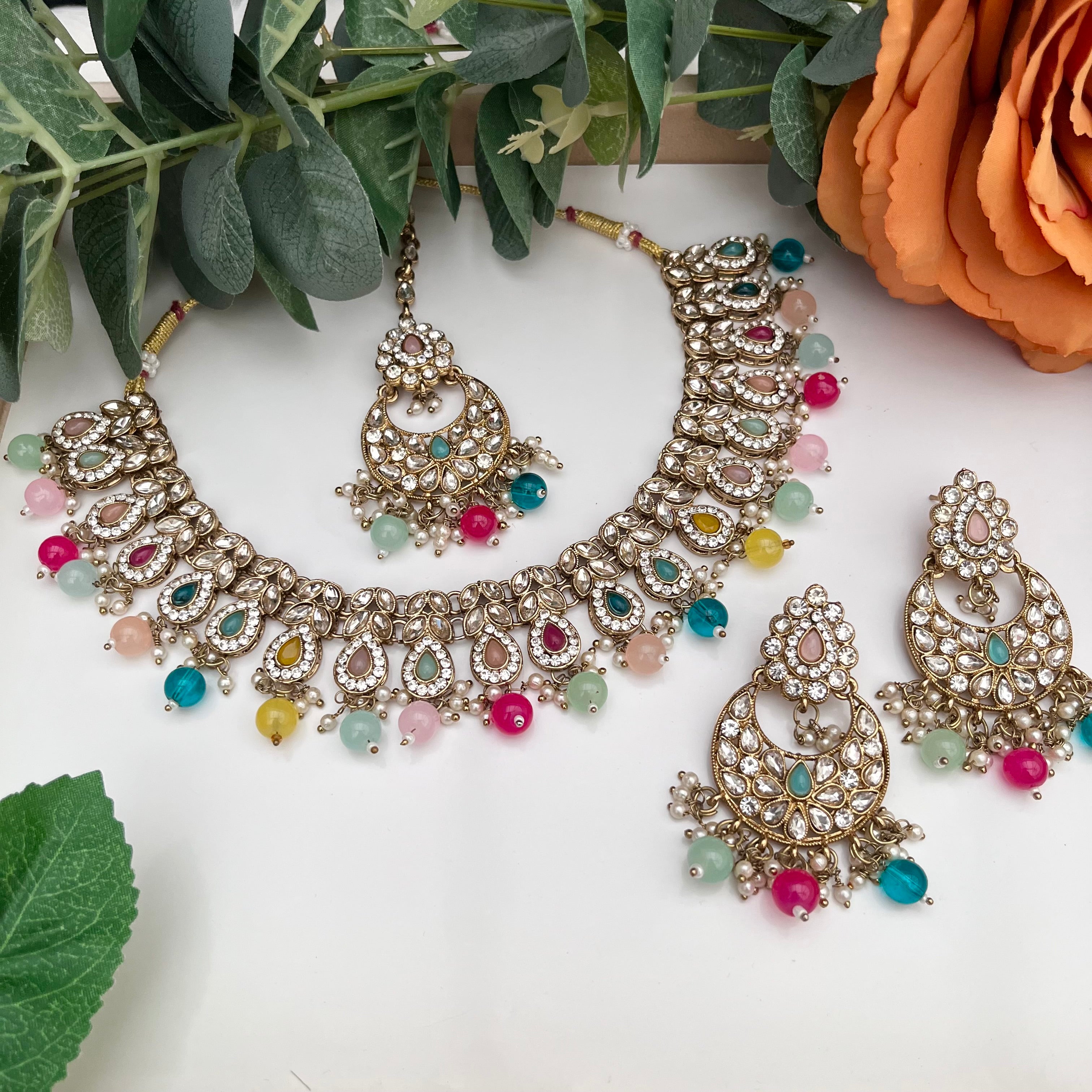 Elegant Multicoloured with gold base necklace with tikka and earrings.