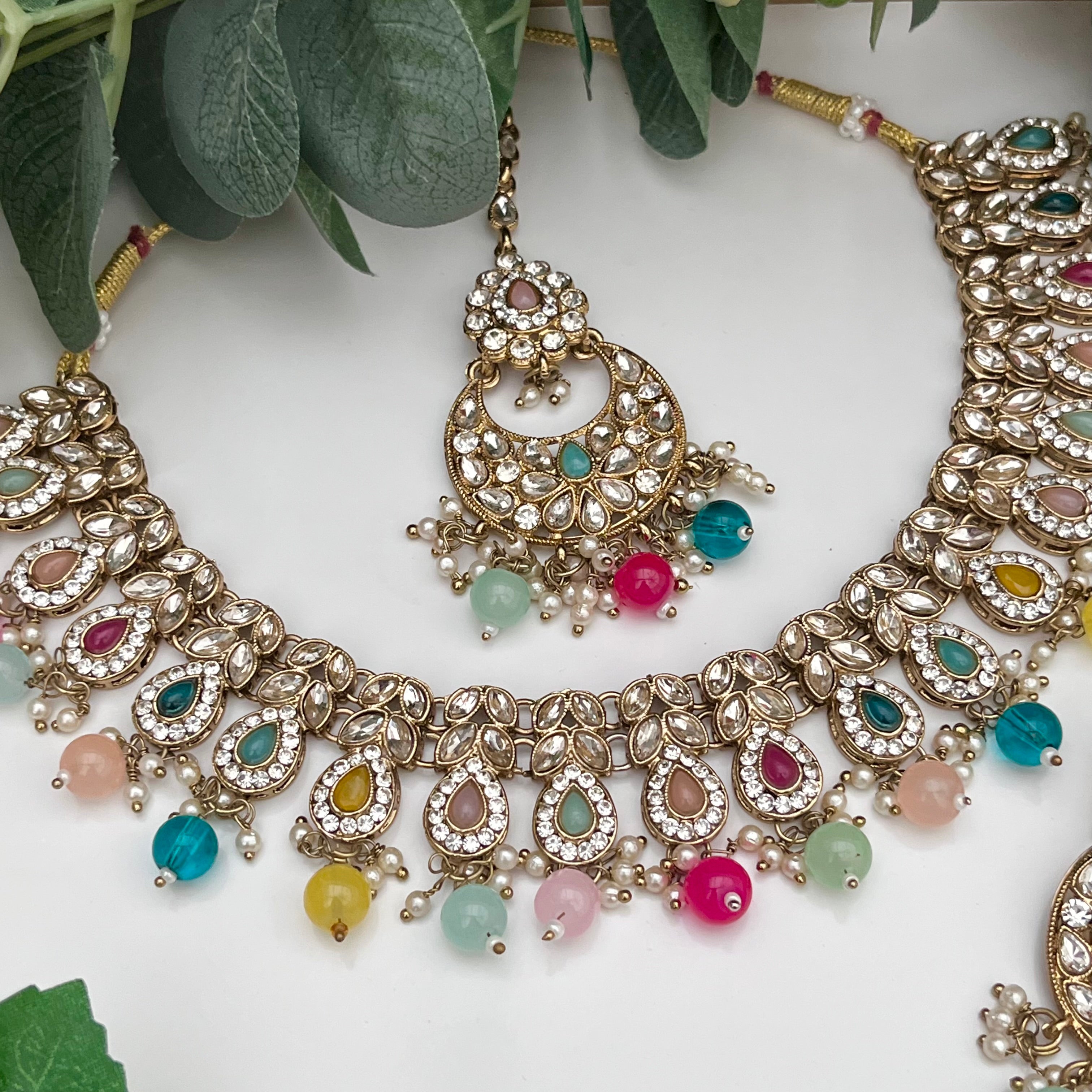 Elegant Multicoloured with gold base necklace with tikka and earrings.