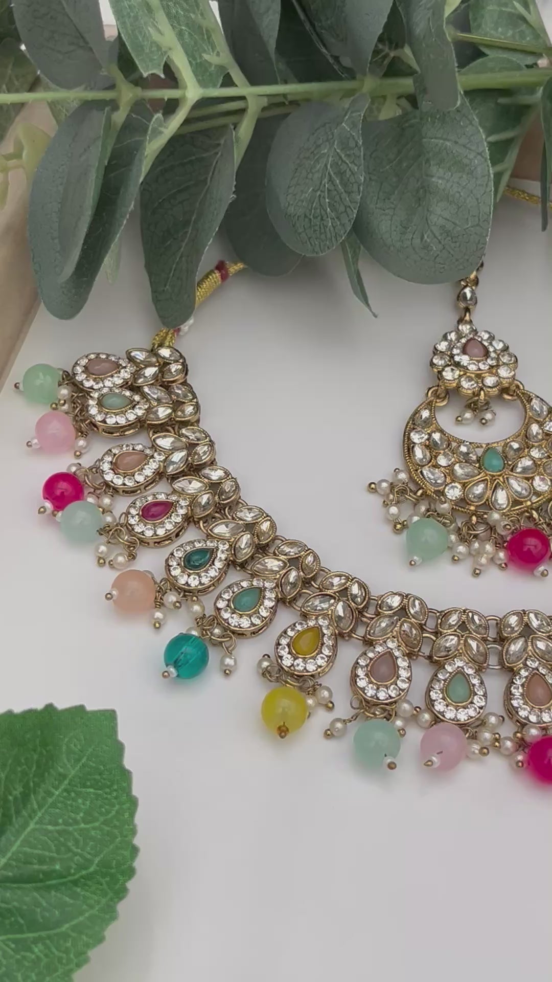 Elegant Multicoloured with gold base necklace with tikka and earrings.